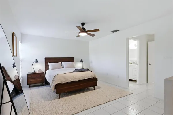 a spacious bedroom with a bed and a ceiling fan