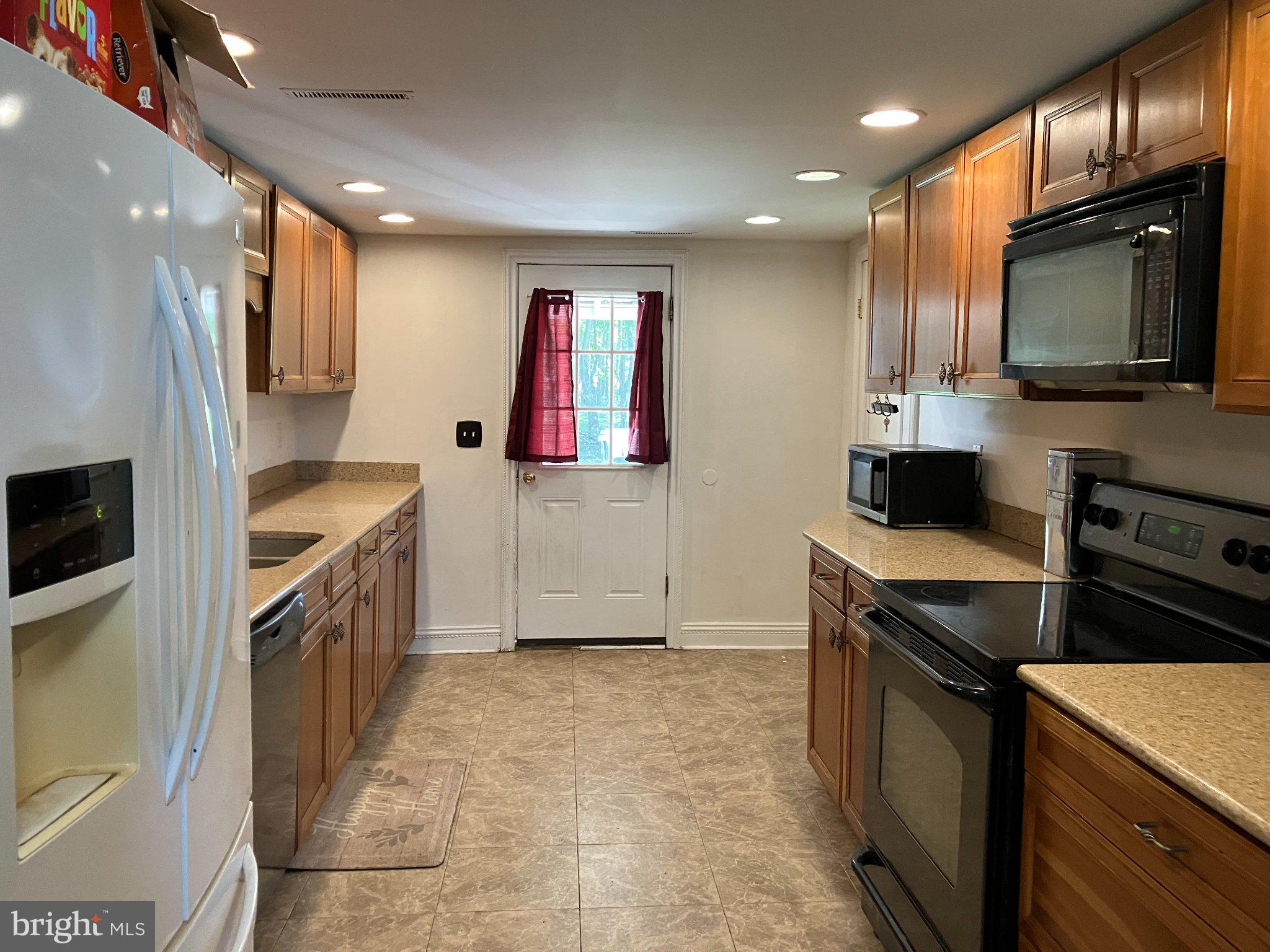 4818 Piney Neck Road Rock Hall, MD 21661 - Photo 3 of 24 a kitchen that has a sink wooden cabinets and stainless steel appliances