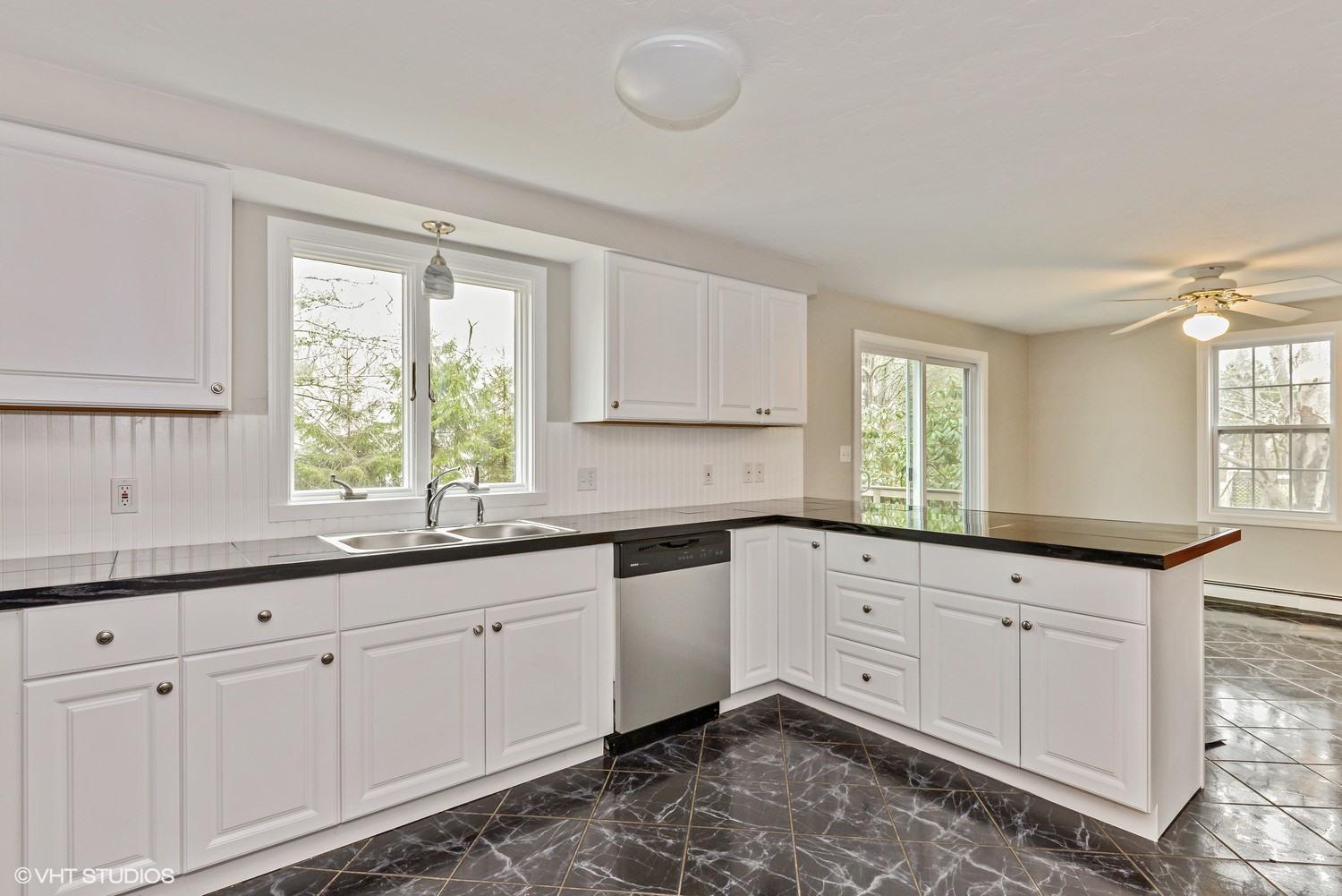 197 Shootflying Hill Road Centerville, MA 02632 - Photo 5 of 15 a kitchen with granite countertop white cabinets and sink