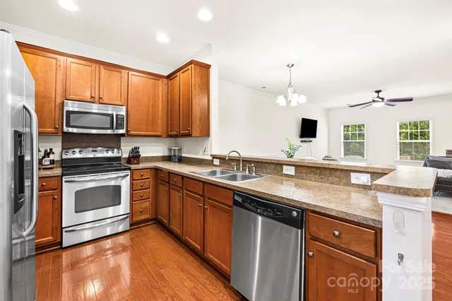 a kitchen with stainless steel appliances granite countertop a sink stove and microwave