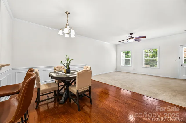 a view of a dining room with furniture wooden floor and a chandelier