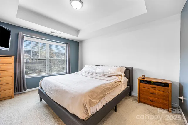 a large bed sitting in a room next to a window