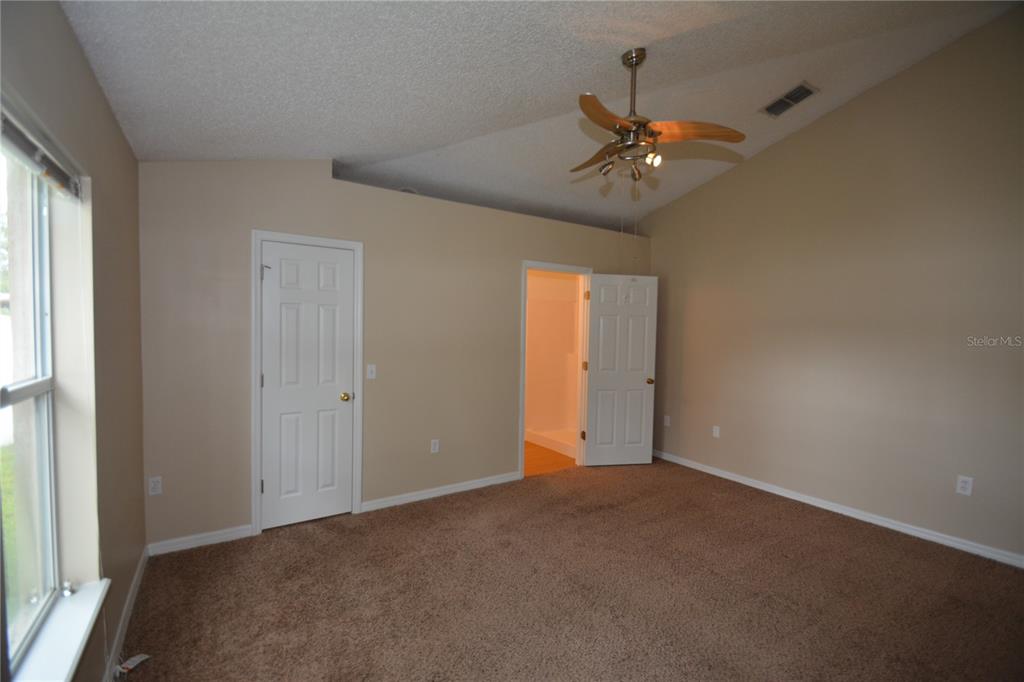 5 Kathleen Trail Palm Coast, FL 32164 - Photo 22 of 38 an empty room with windows and fan