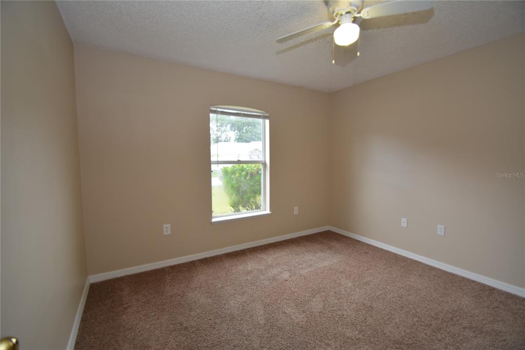 5 Kathleen Trail Palm Coast, FL 32164 - Photo 29 of 38 an empty room with a chandelier fan and windows