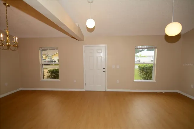 an empty room with windows and chandelier