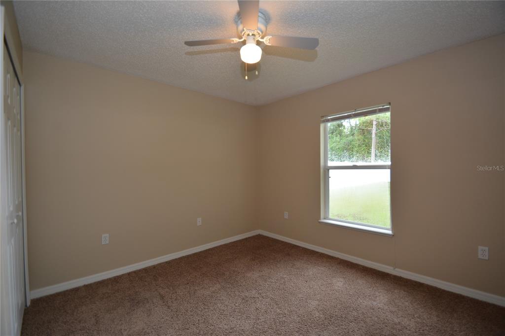 5 Kathleen Trail Palm Coast, FL 32164 - Photo 33 of 38 an empty room with a window and a fan