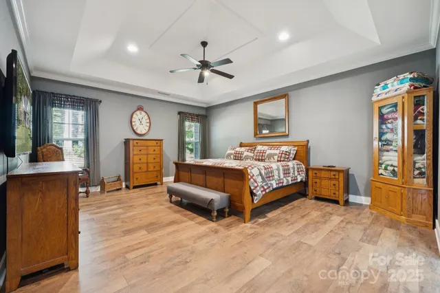 a bedroom with a bed and dresser with wooden floor