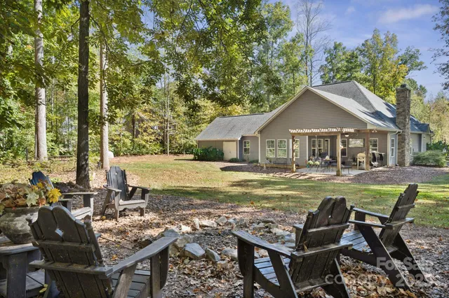 a view of house with backyard outdoor seating and trees