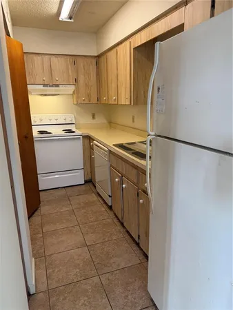 a kitchen with a refrigerator sink and cabinets