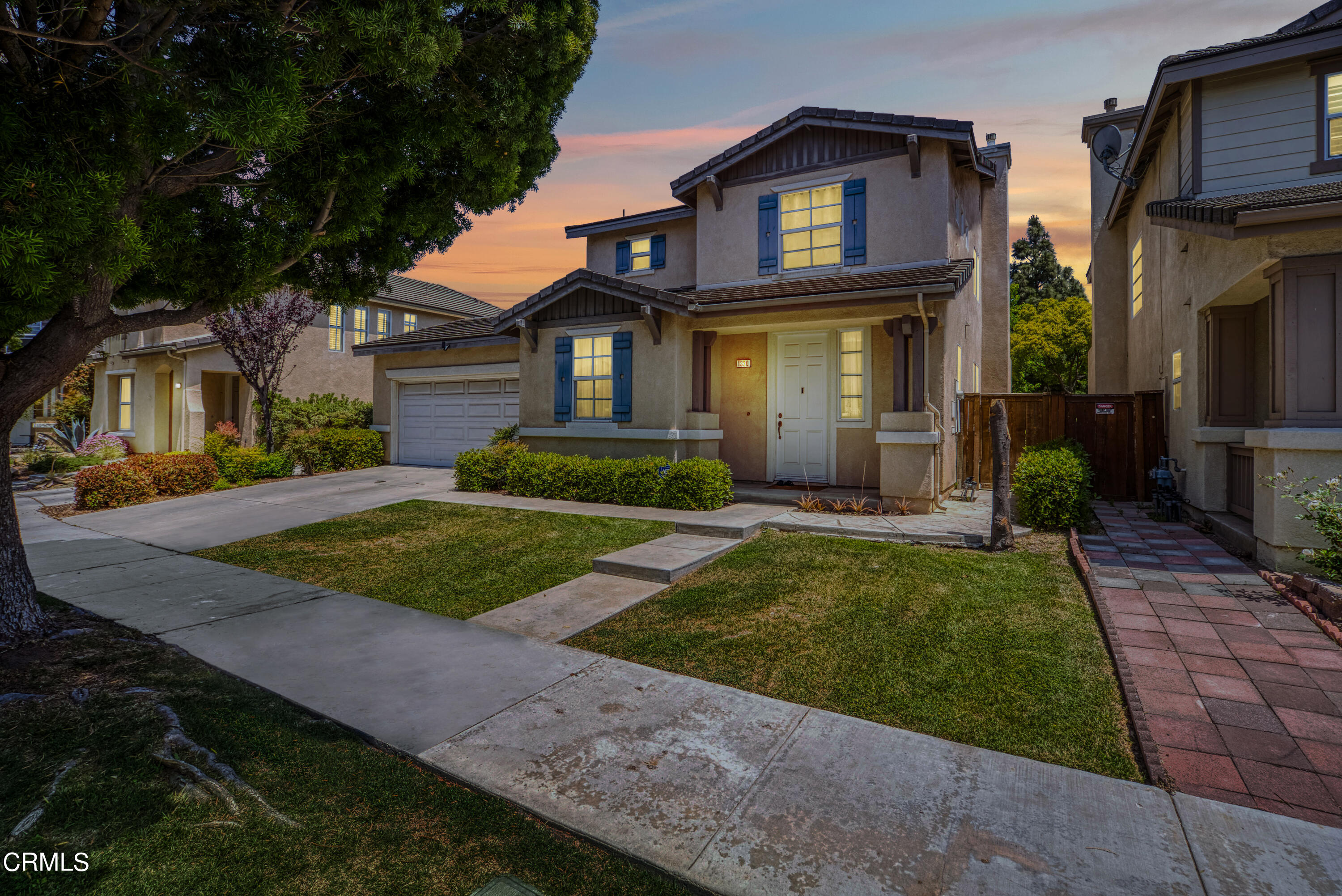 1320 Ribera Place Oxnard, CA 93030 - Photo 2 of 3 a view of a brick house with a yard plants and large tree
