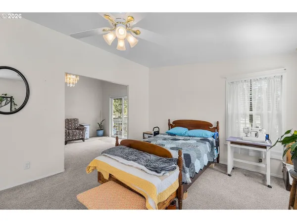 a bedroom with a bed a chandelier and a mirror