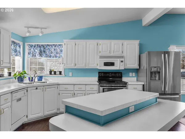 a kitchen with a cabinets and white appliances