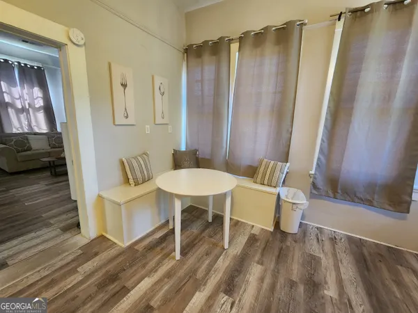 a view of a room with furniture and wooden floor