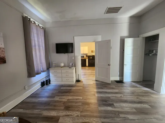 a view of hallway with wooden floor and chair