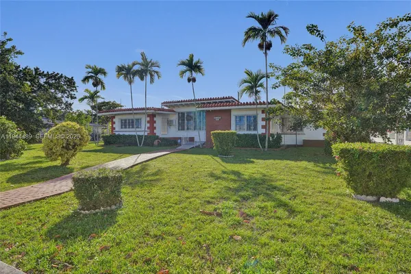 an aerial view of a house with a yard table and chairs