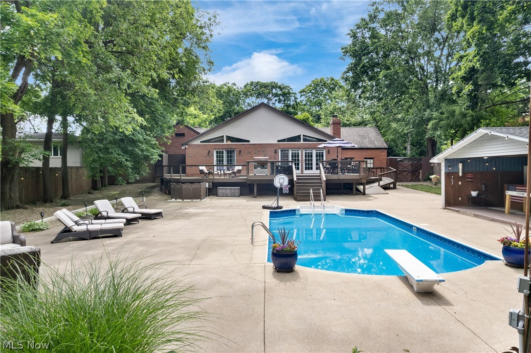 443 Merriman Road Akron, OH 44303 - Photo 35 of 44 Expansive backyard featuring an in-ground swimming pool with diving board, a large concrete patio, and a dedicated pool house