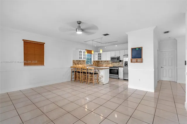 a kitchen with stainless steel appliances kitchen island granite countertop a refrigerator and a stove top oven
