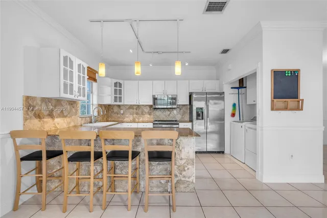 a kitchen with stainless steel appliances granite countertop a refrigerator and a stove top oven