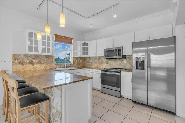 a kitchen with granite countertop a sink stainless steel appliances and counter space