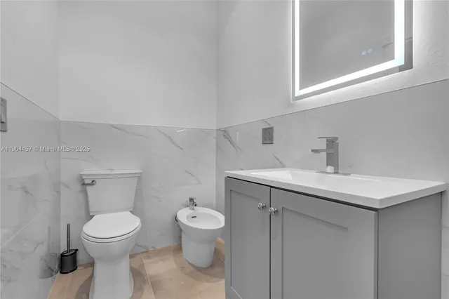 a bathroom with a toilet sink and mirror