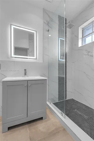 a bathroom with a shower sink and mirror