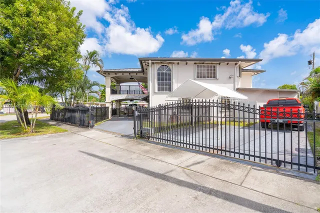 a side view of a house with a iron fence