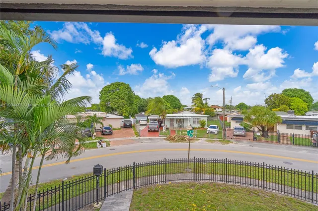 an aerial view of residential houses with outdoor space and parking