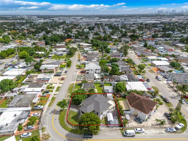 an aerial view of residential houses with outdoor space and parking