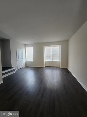 a view of wooden floor and windows in an empty room
