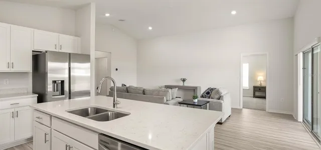 a kitchen with sink refrigerator and stove