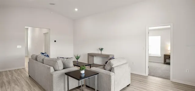 a living room with furniture and a wooden floor