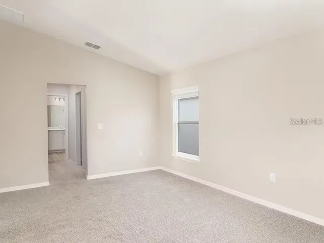 an empty room with windows and closet