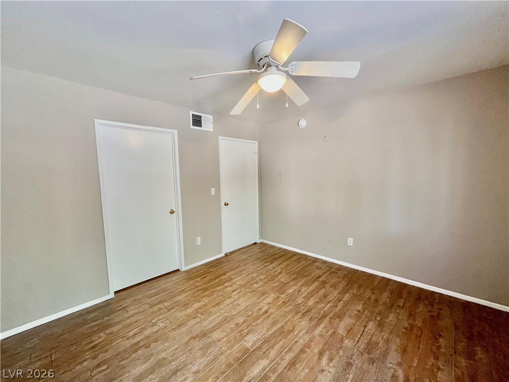 7885 West Flamingo Road, Unit 1029 Las Vegas, NV 89147 - Photo 13 of 18 Well-lit room featuring durable wood-style flooring and a refreshing ceiling fan.
