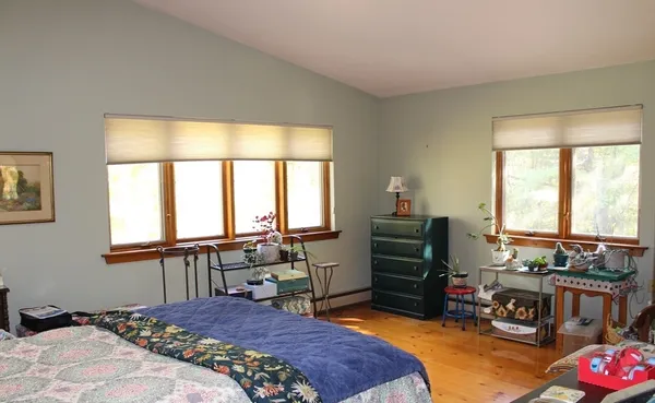 a bedroom with a bed and a large window