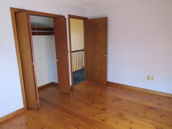 an empty room with wooden floor and a window