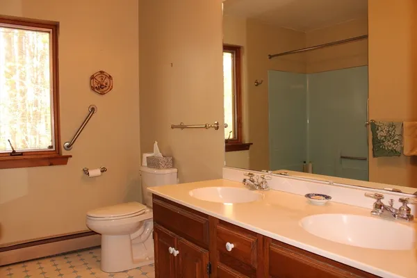 a bathroom with a granite countertop sink a toilet and a mirror