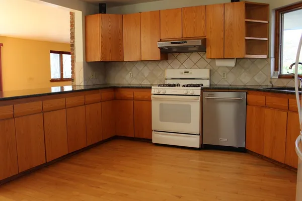 a kitchen with stainless steel appliances granite countertop a sink stove and cabinets