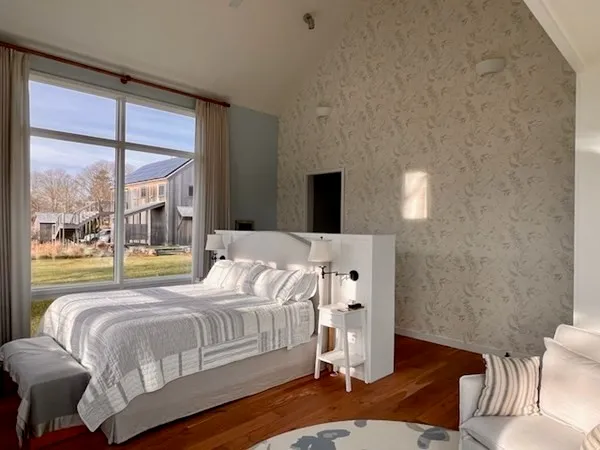 a bedroom with a bed and a large window