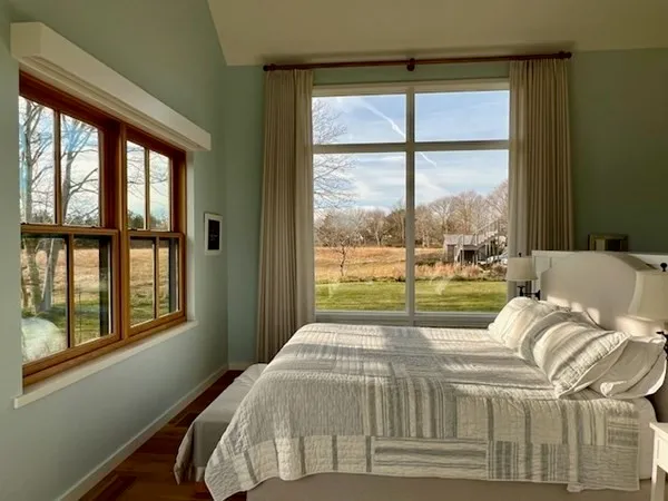 a bed sitting in a bedroom next to a window