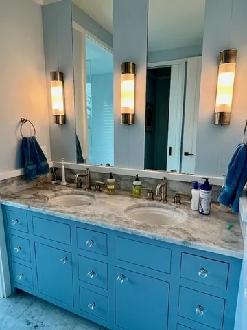 a bathroom with double vanity sinks and a mirror