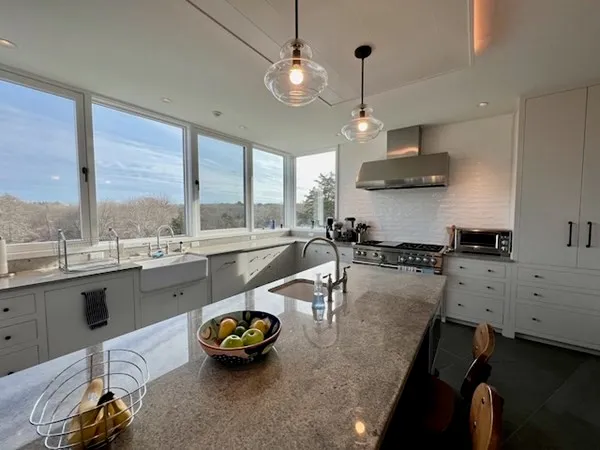 a kitchen with a large window and stainless steel appliances