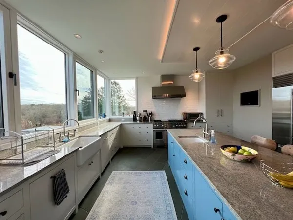 a large kitchen with a large window and stainless steel appliances