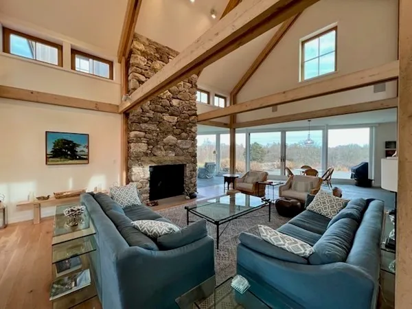 a living room with furniture a fireplace and a floor to ceiling window