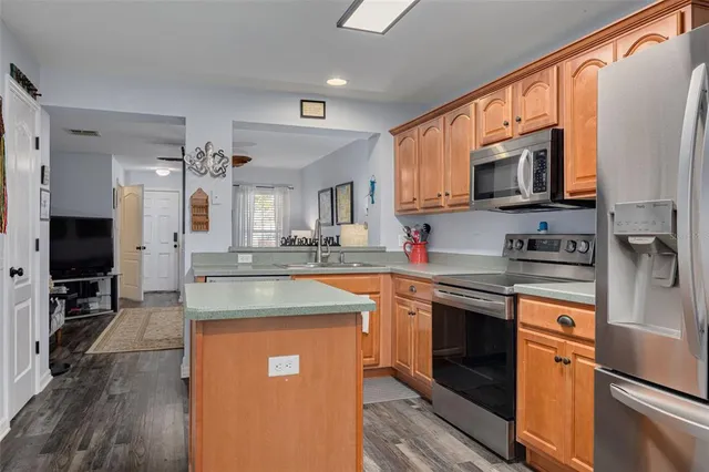 a kitchen with stainless steel appliances granite countertop a sink stove and refrigerator