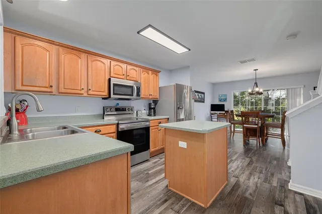 a kitchen with a sink a counter top space and stainless steel appliances
