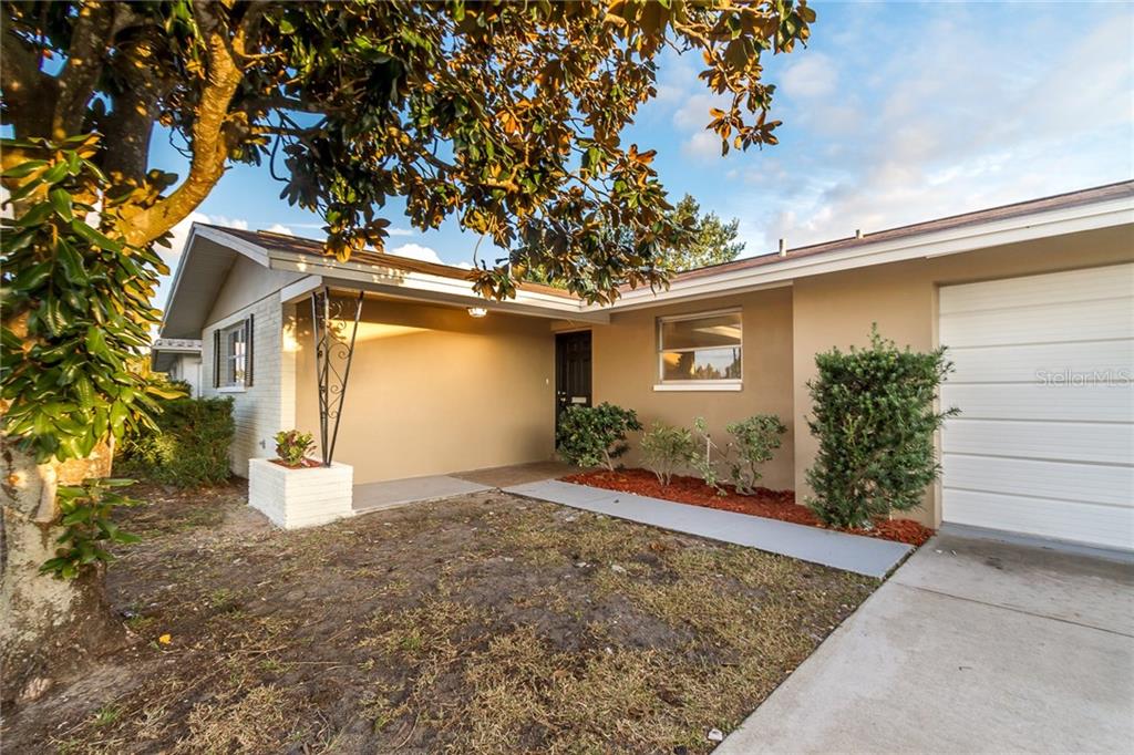 7600 Jasmine Boulevard Port Richey, FL 34668 - Photo 1 of 1 a front view of a house with a yard and garage
