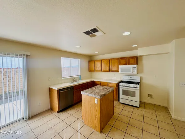 a kitchen with stainless steel appliances granite countertop a stove top oven and cabinets