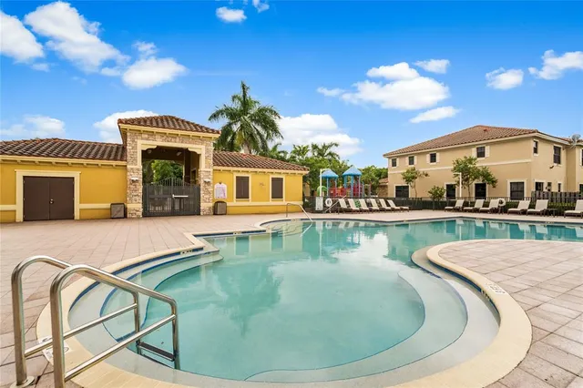 a large room with chandelier fan and windows