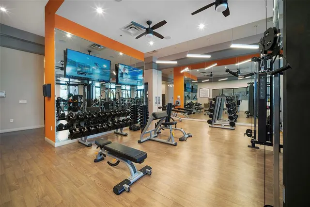 a living room with furniture gym equipment and a large window