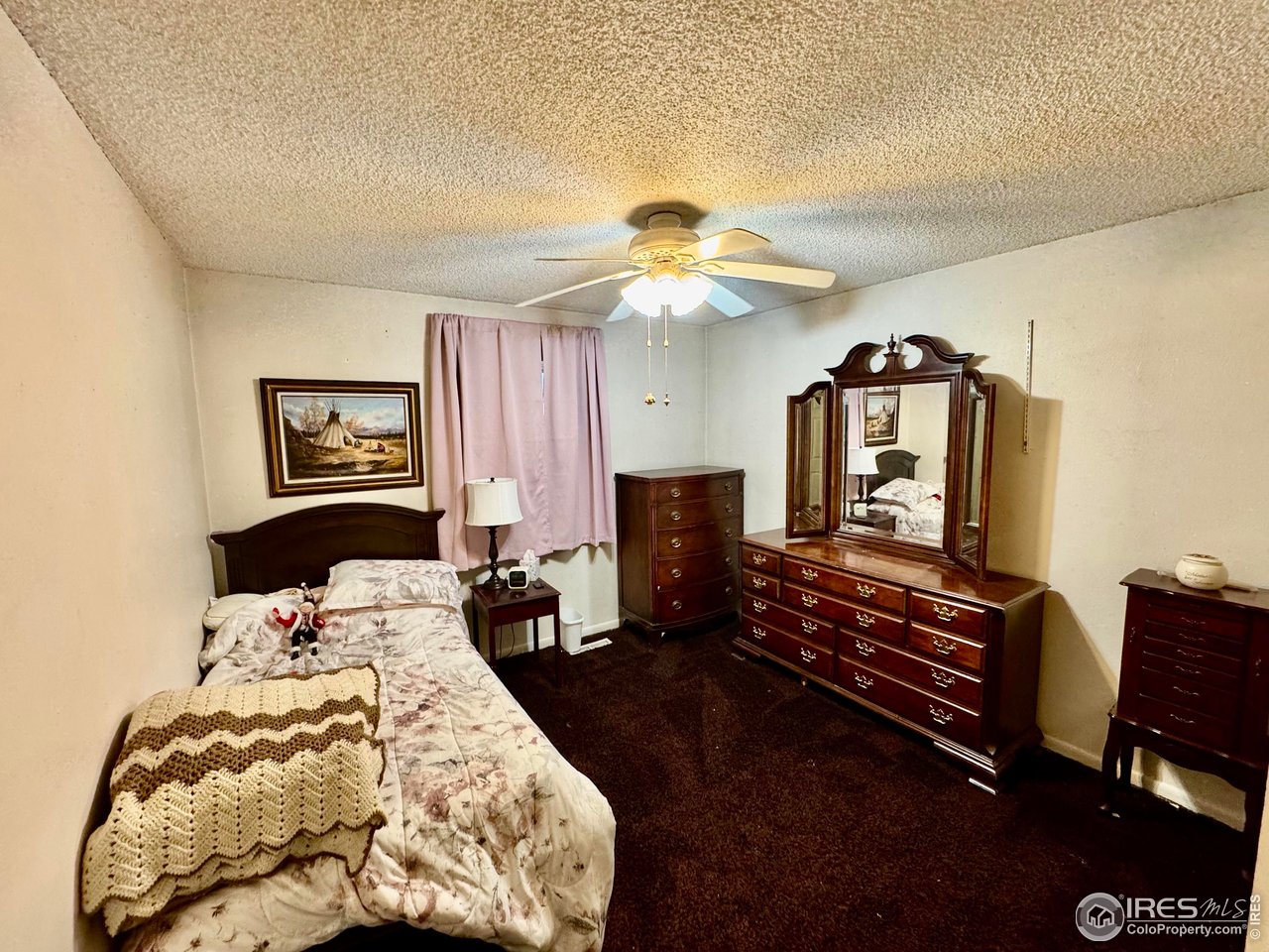 1924 30th Street Road Greeley, CO 80631 - Photo 13 of 19 a bedroom with a bed and dresser with mirror